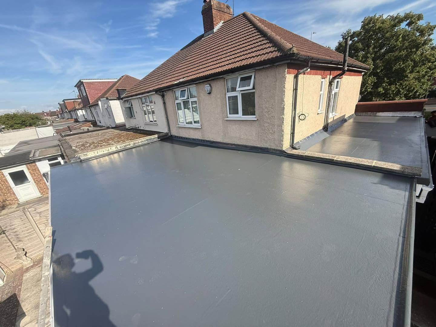 New grey flat roofing across a house extension